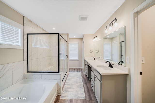 bathroom featuring a bath, visible vents, a stall shower, and a sink
