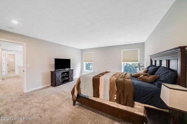 bedroom with light colored carpet and baseboards