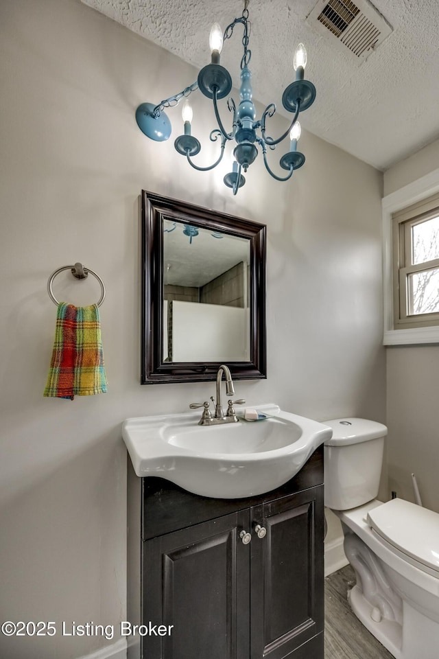 3140 Yorkshire Dr, Bardstown, KY 40004 - half bathroom featuring a textured ceiling, visible vents, an inviting chandelier, and toilet