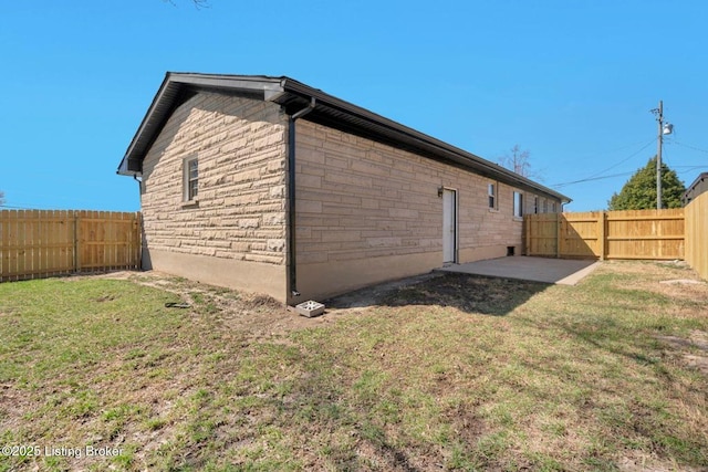 view of side of property with a patio, a yard, and a fenced backyard