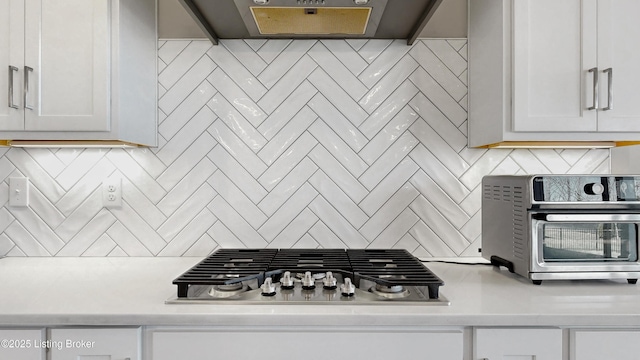 kitchen featuring tasteful backsplash, stainless steel gas stovetop, and light countertops