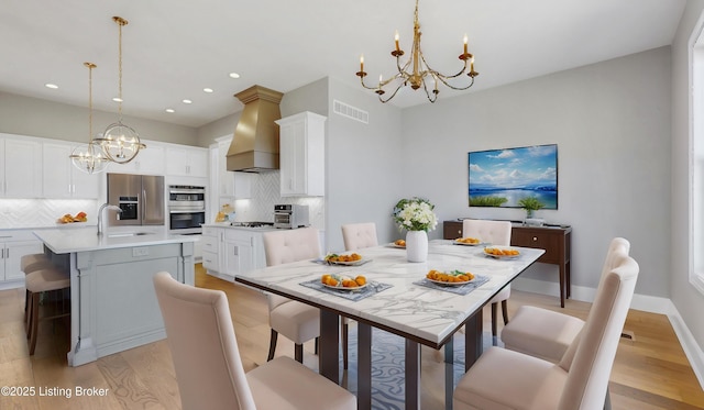 dining area featuring visible vents, baseboards, light wood-type flooring, recessed lighting, and a notable chandelier