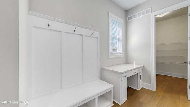 mudroom featuring visible vents, baseboards, and wood finished floors