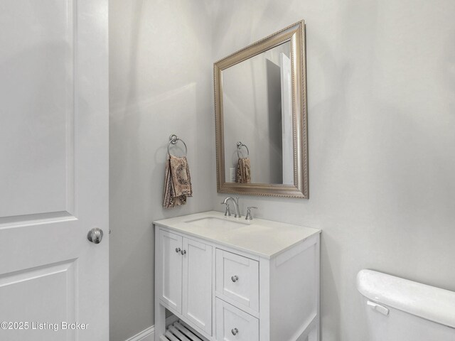 half bath featuring toilet and vanity