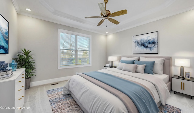bedroom with visible vents, baseboards, ornamental molding, light carpet, and a raised ceiling