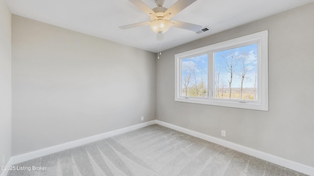 empty room with visible vents, baseboards, light colored carpet, and a ceiling fan