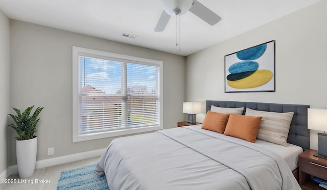 carpeted bedroom featuring a ceiling fan, visible vents, and baseboards