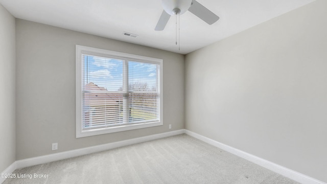 carpeted spare room with a ceiling fan, baseboards, and visible vents