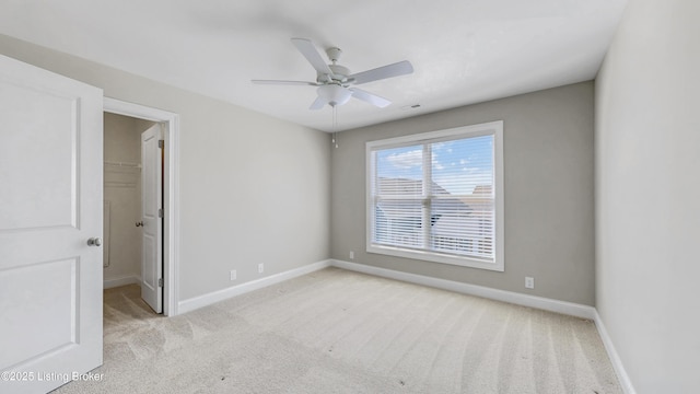carpeted empty room with visible vents, ceiling fan, and baseboards