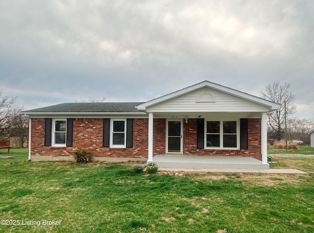 single story home with brick siding, a front yard, and a shingled roof