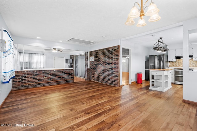 268 Cobb Rd, Eminence, KY 40019 - unfurnished living room with brick wall, light wood finished floors, and ceiling fan with notable chandelier