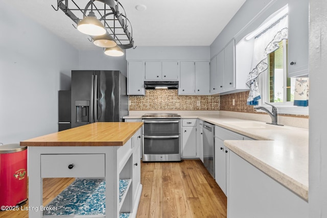 268 Cobb Rd, Eminence, KY 40019 - kitchen with under cabinet range hood, wooden counters, a sink, backsplash, and appliances with stainless steel finishes