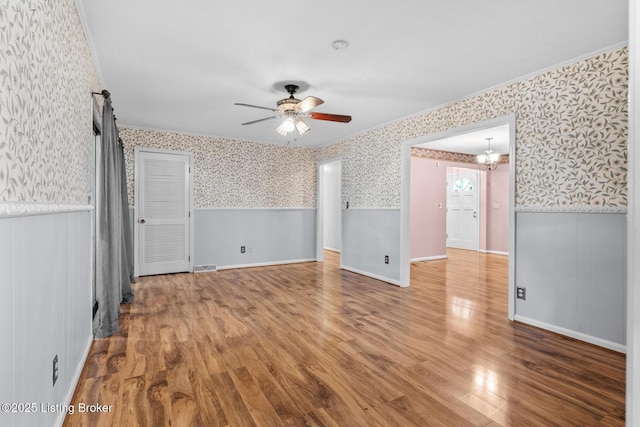 268 Cobb Rd, Eminence, KY 40019 - spare room with a ceiling fan, wallpapered walls, wainscoting, visible vents, and wood finished floors