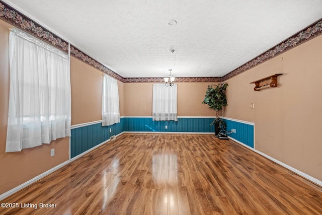 268 Cobb Rd, Eminence, KY 40019 - spare room with baseboards, a notable chandelier, a wainscoted wall, and wood finished floors