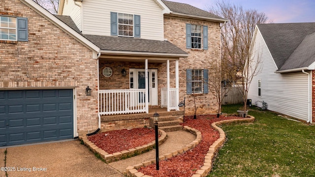 4316 Arwine Ct, Louisville, KY 40245 - traditional-style house featuring a front yard, driveway, covered porch, a shingled roof, and brick siding