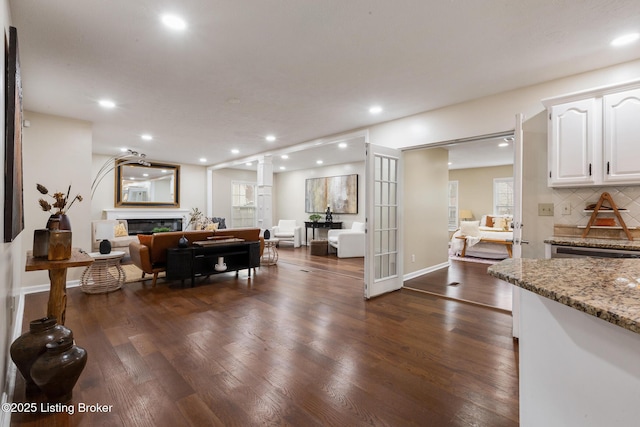 4316 Arwine Ct, Louisville, KY 40245 - living room featuring baseboards, recessed lighting, dark wood-style floors, a glass covered fireplace, and ornate columns