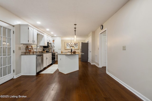 4316 Arwine Ct, Louisville, KY 40245 - kitchen featuring dark wood-style floors, dark stone counters, stainless steel appliances, white cabinetry, and a notable chandelier