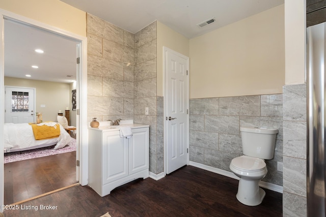 4316 Arwine Ct, Louisville, KY 40245 - ensuite bathroom with visible vents, toilet, wood finished floors, connected bathroom, and tile walls