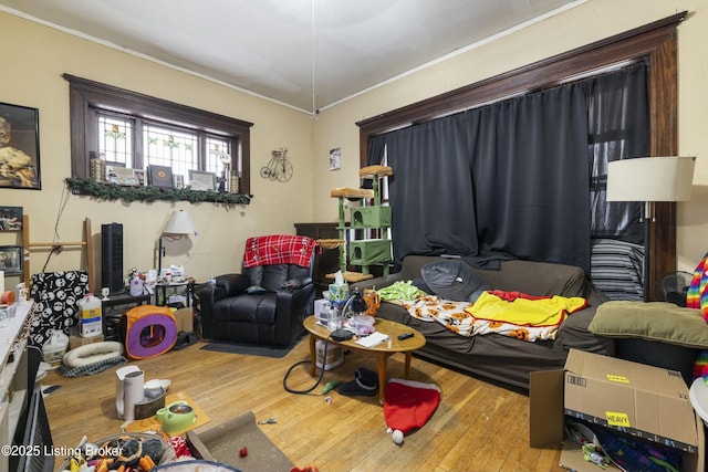 living area with hardwood / wood-style flooring and ornamental molding