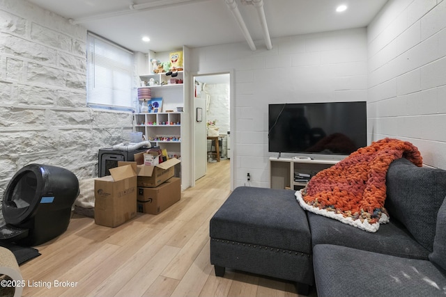 living area featuring beam ceiling and wood finished floors