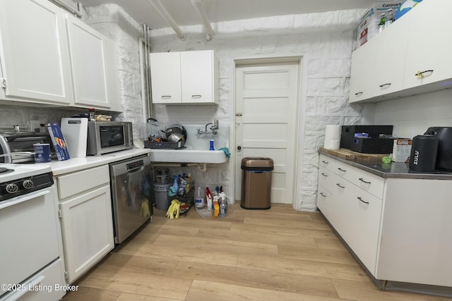 kitchen with white cabinets, light wood-type flooring, and appliances with stainless steel finishes