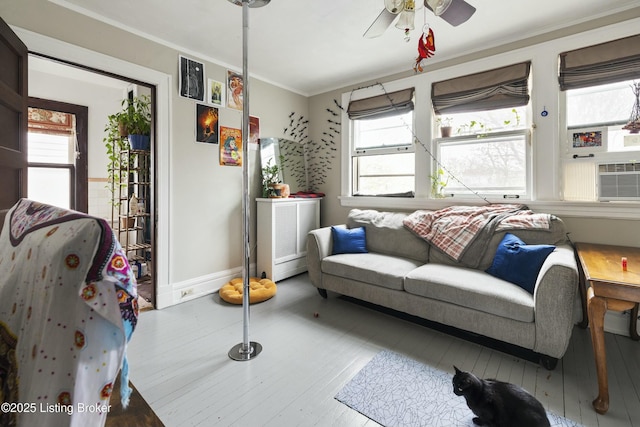 living area featuring hardwood / wood-style flooring, plenty of natural light, a ceiling fan, and ornamental molding