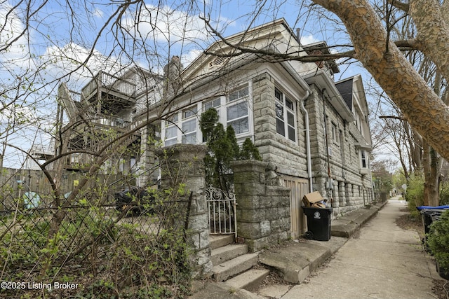 view of side of property featuring stone siding and a chimney