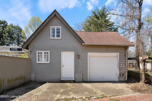 garage featuring driveway and fence