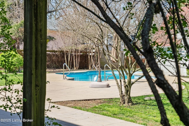 view of swimming pool featuring fence
