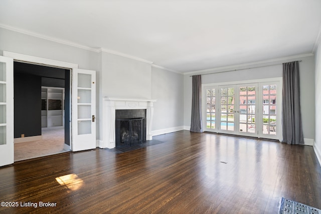 unfurnished living room featuring baseboards, french doors, crown molding, a fireplace with flush hearth, and wood finished floors
