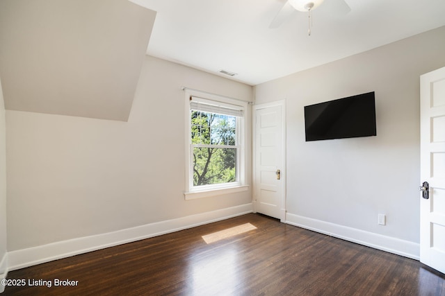 interior space featuring visible vents, baseboards, ceiling fan, dark wood-style floors, and vaulted ceiling
