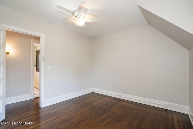 empty room featuring ceiling fan, baseboards, lofted ceiling, and dark wood-style flooring