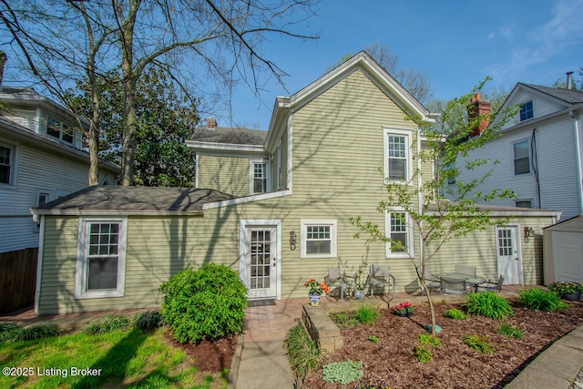 view of front of house with a shed, a patio, and an outbuilding