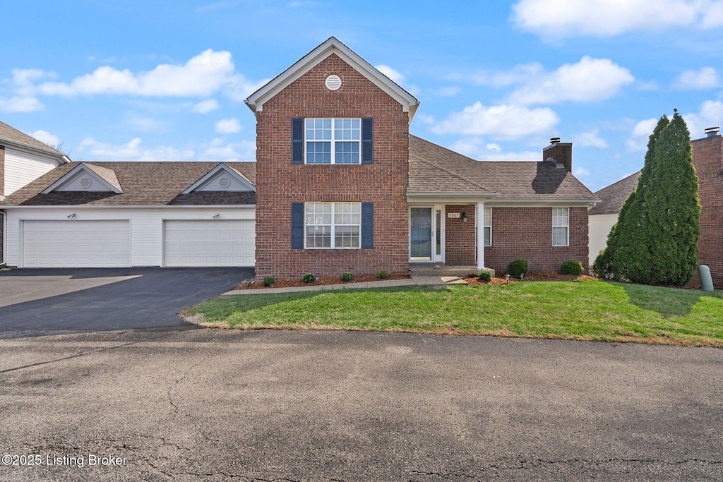 1501 Eagle Nest Way, Lyndon, KY 40222 - traditional-style house with driveway, an attached garage, brick siding, a front lawn, and a chimney