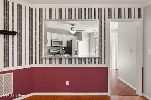 1501 Eagle Nest Way, Lyndon, KY 40222 - kitchen with appliances with stainless steel finishes, wood finished floors, baseboards, white cabinetry, and a ceiling fan