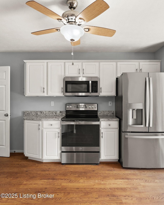 1501 Eagle Nest Way, Lyndon, KY 40222 - kitchen with appliances with stainless steel finishes, white cabinets, a ceiling fan, and light stone counters