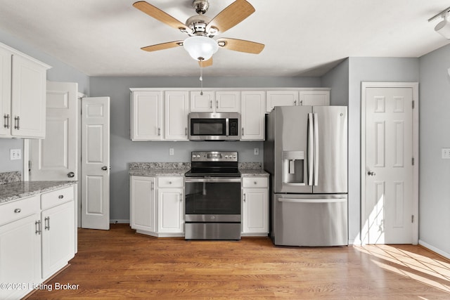 1501 Eagle Nest Way, Lyndon, KY 40222 - kitchen featuring stainless steel appliances, ceiling fan, white cabinetry, light wood-style flooring, and light stone counters