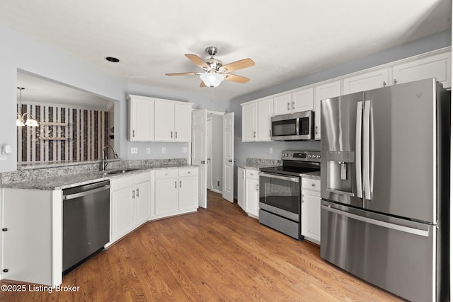 1501 Eagle Nest Way, Lyndon, KY 40222 - kitchen with appliances with stainless steel finishes, a ceiling fan, white cabinets, a sink, and light wood-style flooring