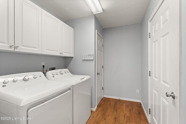 1501 Eagle Nest Way, Lyndon, KY 40222 - laundry area with cabinet space, washing machine and dryer, wood finished floors, baseboards, and a textured ceiling