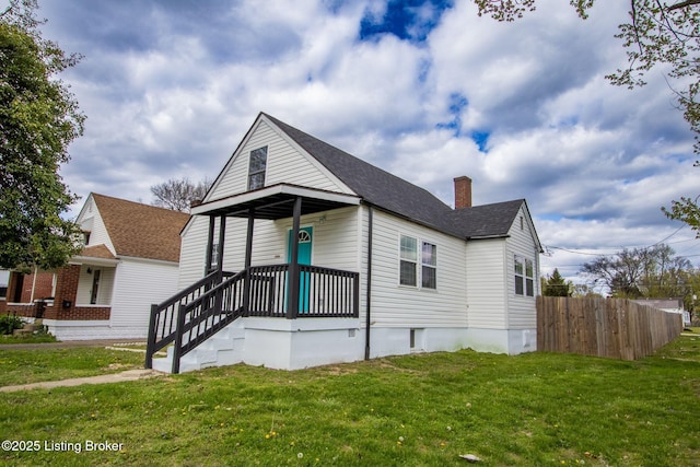 1301 Central Ave, Louisville, KY 40215 - view of front of house featuring roof with shingles, a chimney, fence, and a front lawn