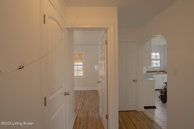 1301 Central Ave, Louisville, KY 40215 - hall with arched walkways, a sink, and light wood-style floors