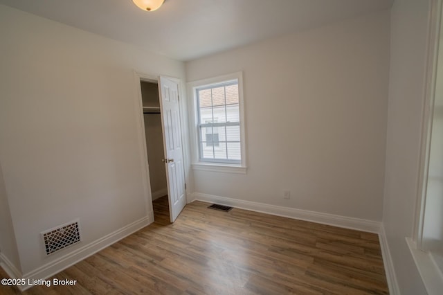 1301 Central Ave, Louisville, KY 40215 - unfurnished bedroom with visible vents, baseboards, a closet, and wood finished floors