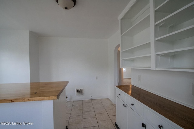 1301 Central Ave, Louisville, KY 40215 - kitchen featuring light tile patterned floors, arched walkways, white cabinetry, visible vents, and wood counters