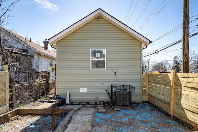rear view of house featuring cooling unit and a fenced backyard