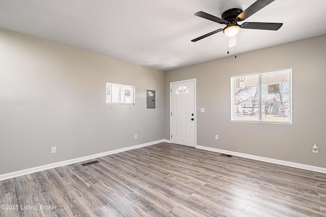 foyer with visible vents, electric panel, wood finished floors, baseboards, and ceiling fan