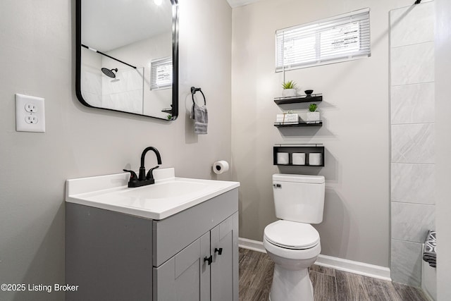full bath with baseboards, toilet, wood finished floors, and vanity