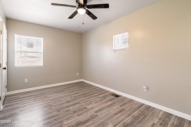 unfurnished room with visible vents, ceiling fan, baseboards, and wood finished floors