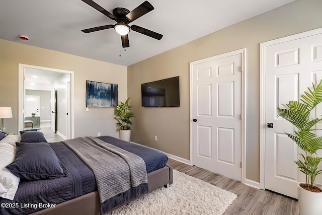 bedroom featuring light wood-type flooring, baseboards, and a ceiling fan