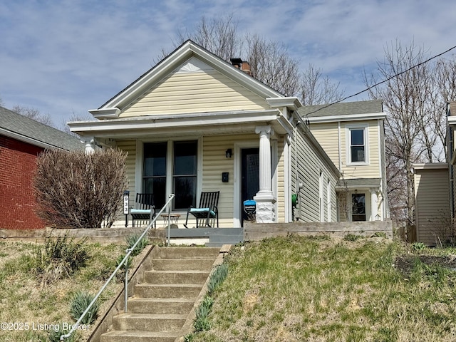 shotgun-style home with covered porch and a chimney