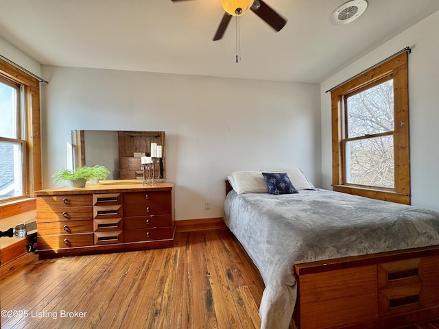 bedroom with hardwood / wood-style flooring, multiple windows, and baseboards